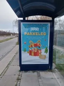 Wolt Pakkeleg Christmas poster at a bus stop shelter in Hvidovre