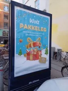 Wolt Pakkeleg Christmas poster on a street advertising display in Copenhagen